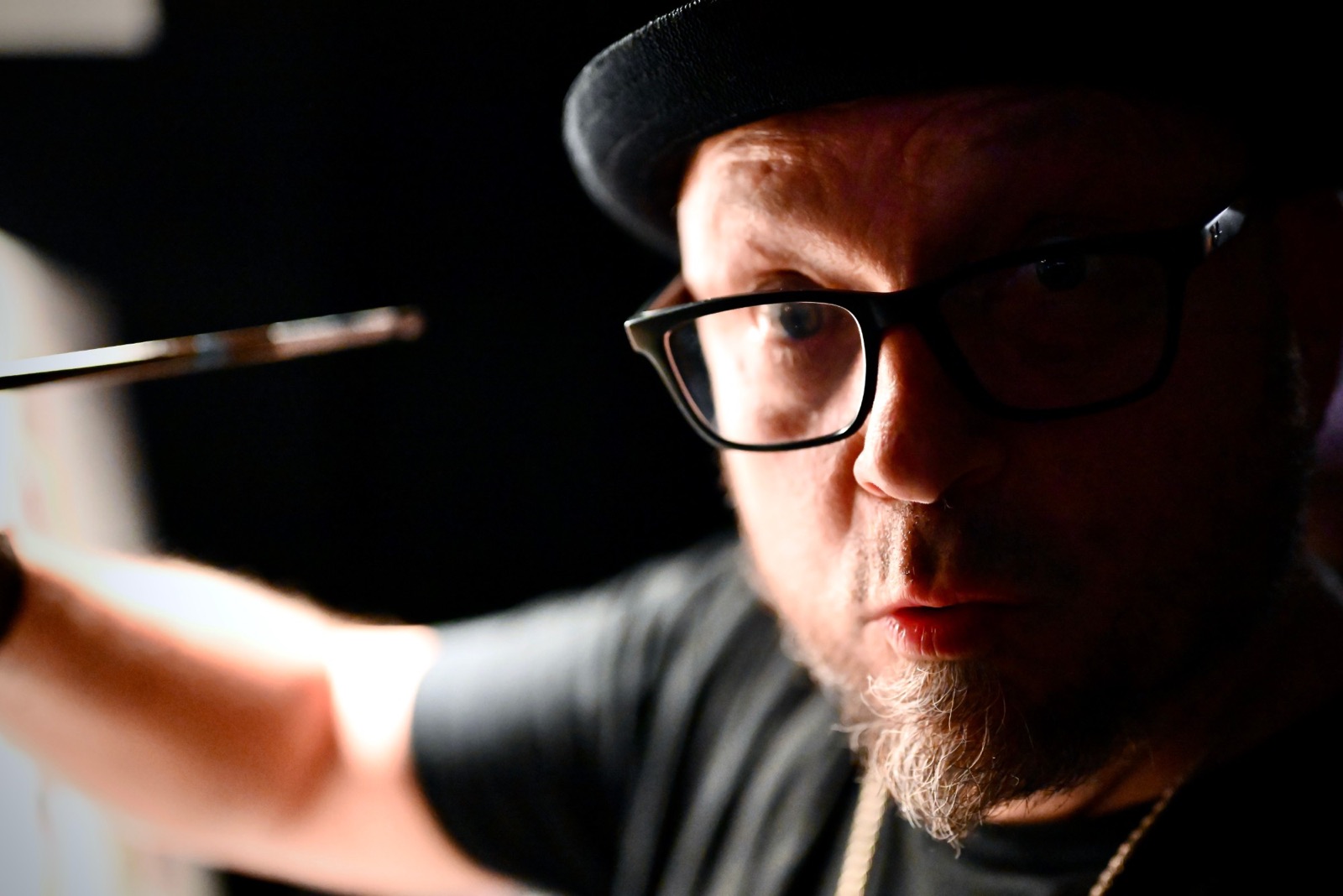 Portrait of Frenchy in his black hat and glasses, brush in hand